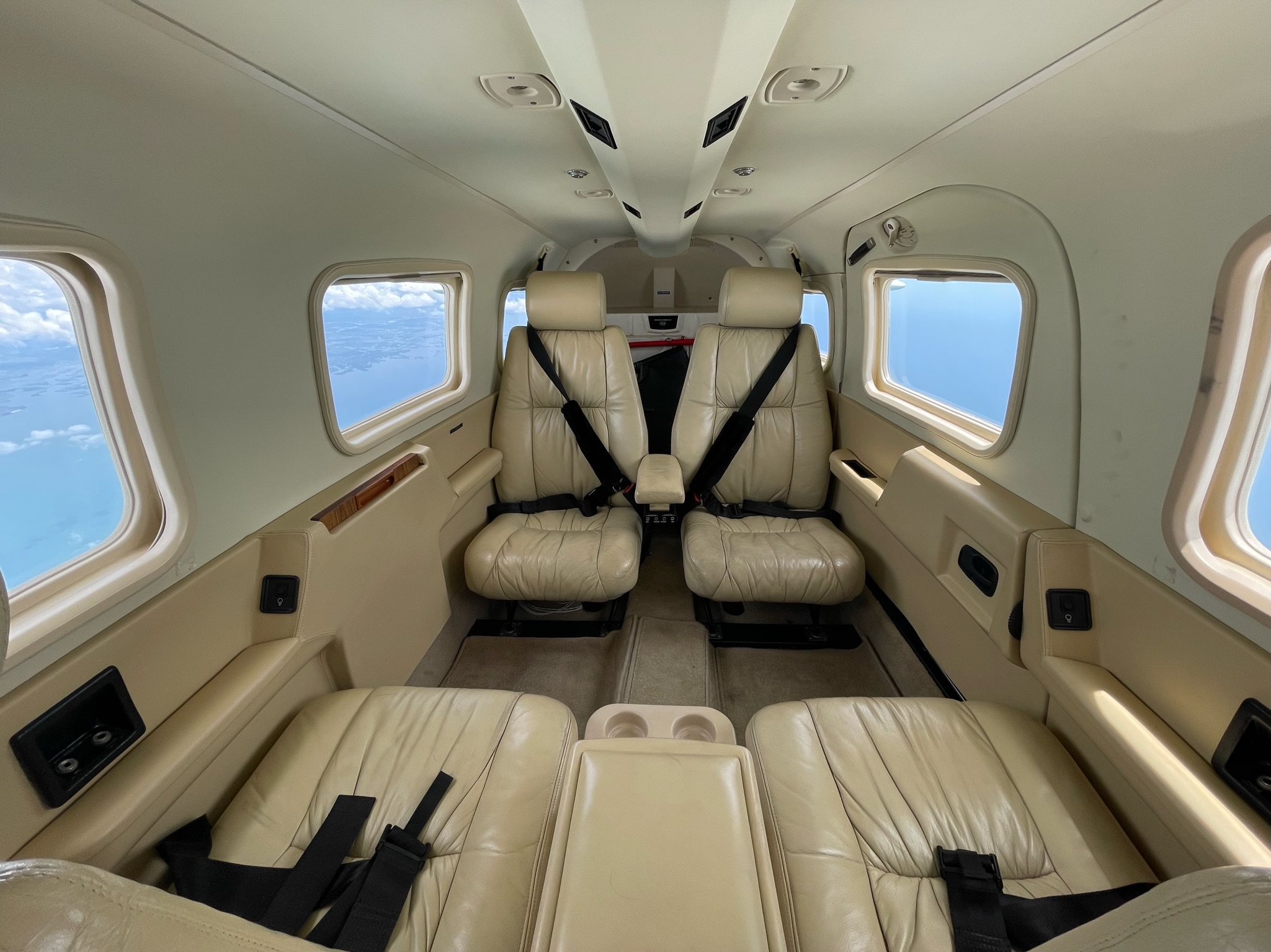 Interior view of Piper Saratoga aircraft featuring comfortable club seating for up to four passengers, perfect for private air charters.